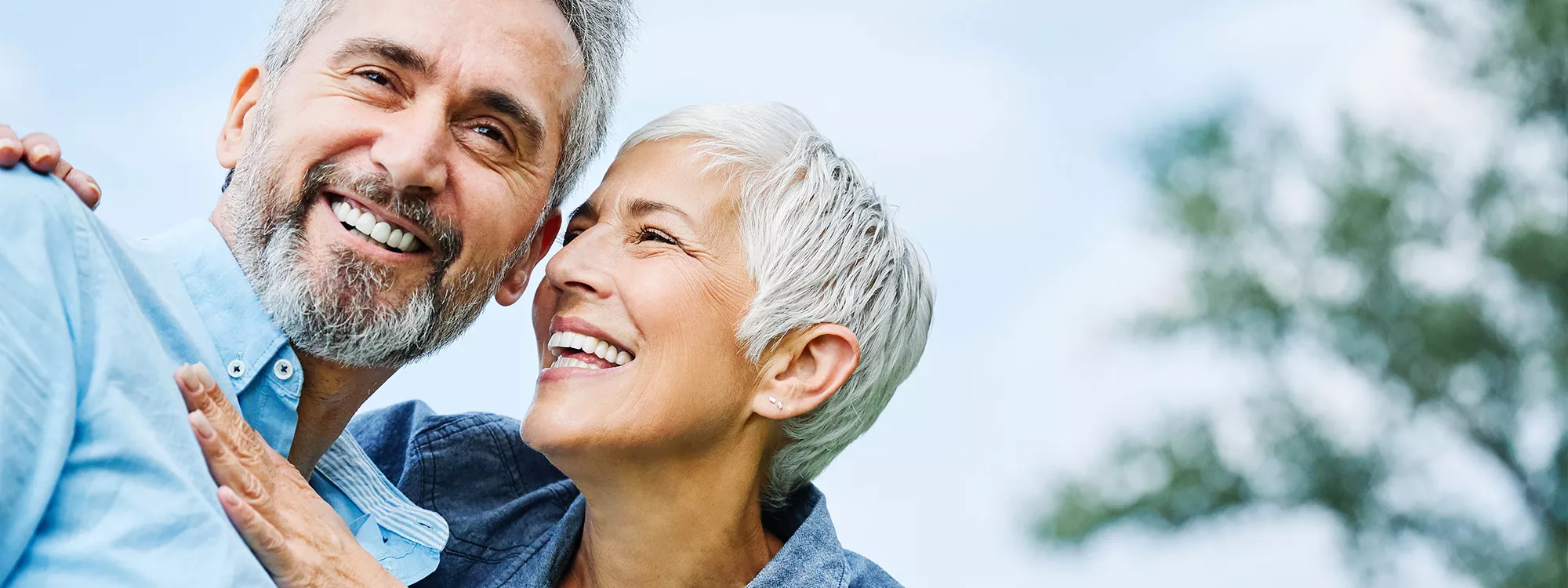 Older smiling couple outside